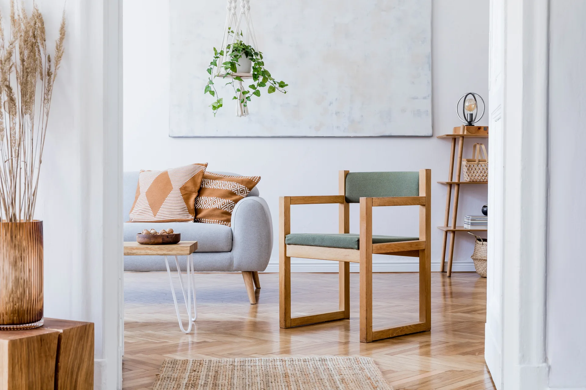 Helles, modern eingerichtetes Wohnzimmer mit Sofa, Sessel und Zimmerpflanzen